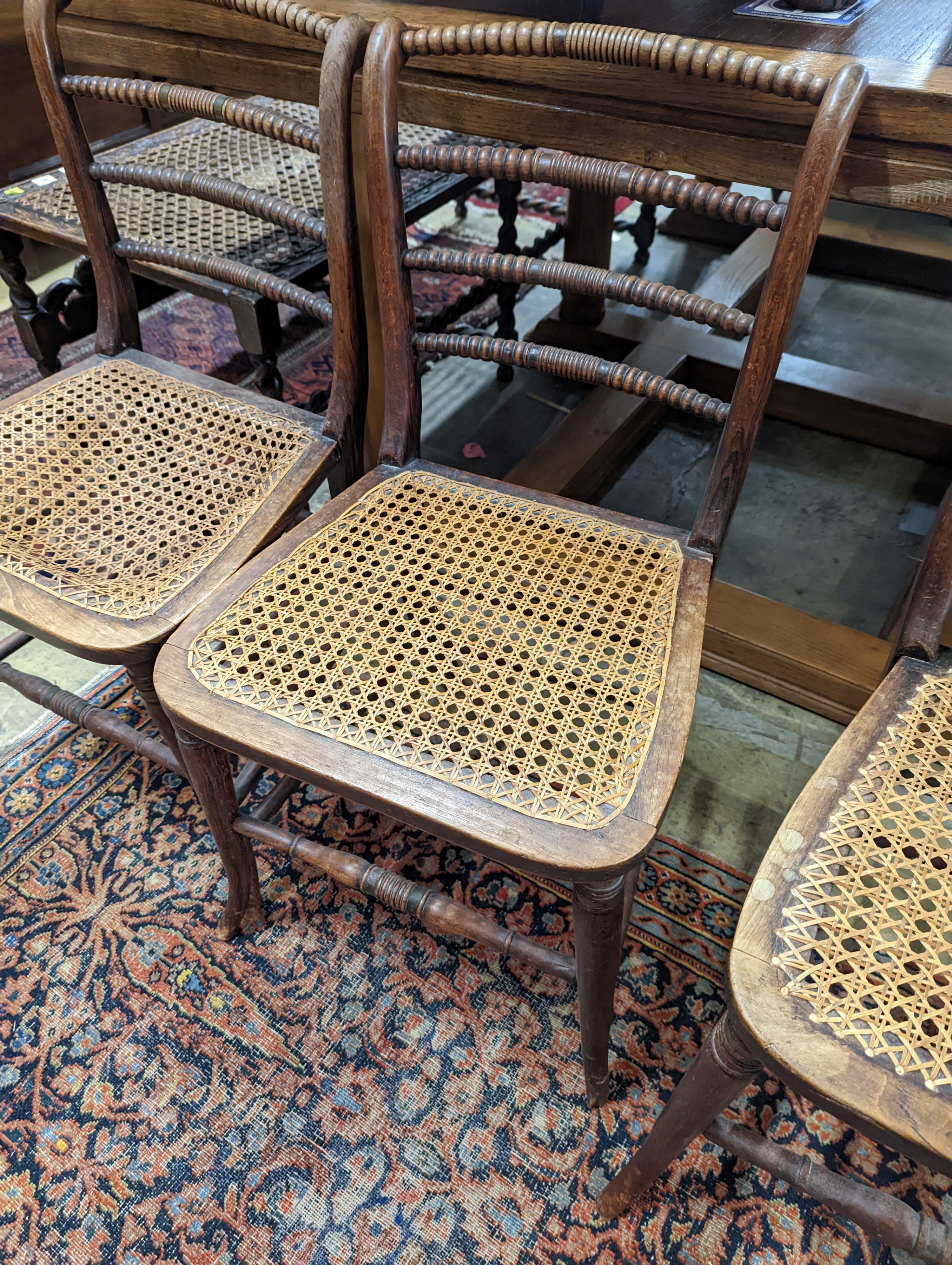 A set of three Regency provincial simulated rosewood cane seated dining chairs